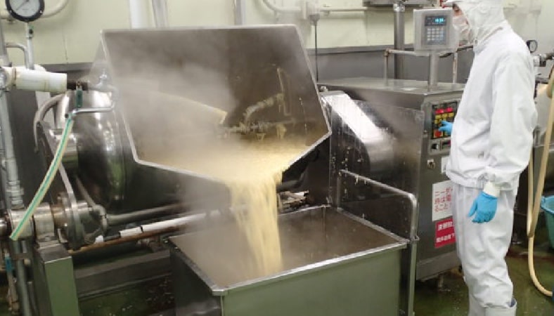 はじめに、ニーダーと呼ばれる大きな釜でスープを作り、煮立ったところに液卵を流し込んでいきます。